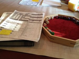 Dice tray with dice, and a Pathfinder RPG character sheet.